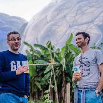 Men enjoying a drink in front of Eden's Biomes